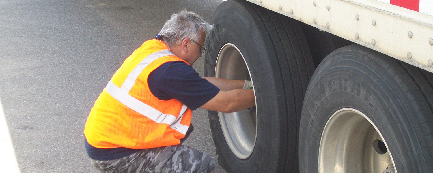 TransPro driver inspecting wheel